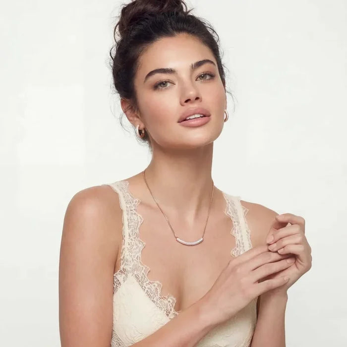 Pink Pavé Zirconia Necklace with a slim rose gold curved bar pendant set with pink stones, worn on a fine chain