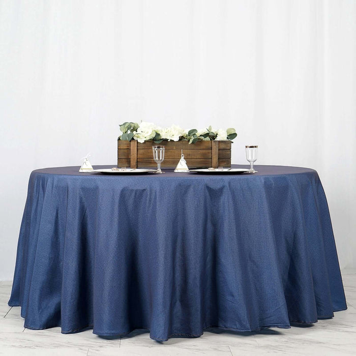 Round navy tablecloth on a styled dining table with floral centerpiece.
