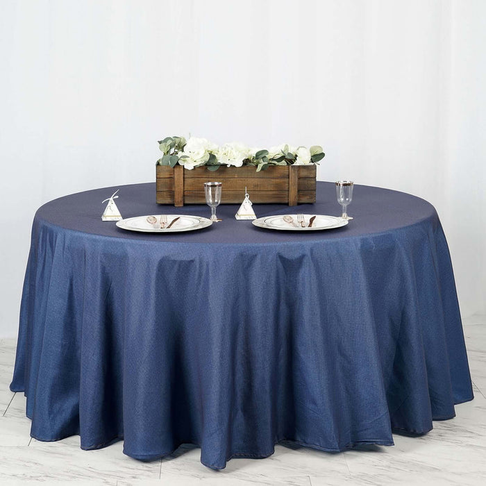 Round navy blue tablecloth draped over a table set for dining.