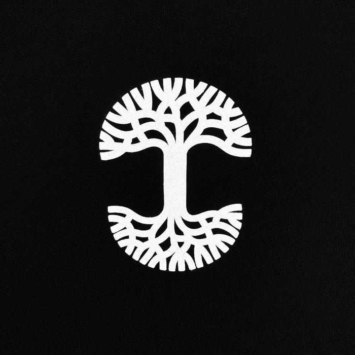 The Posy Tee from Oaklandish features a symmetrical and stylized white tree design that forms a circular shape on a black cotton t-shirt. Its branching patterns extend both upwards and downwards, resembling roots and branches to create a balanced, mirror-like appearance in the men's collection.
