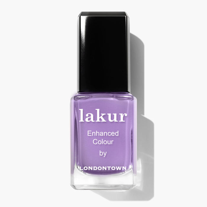 A bottle of LONDONTOWN'S Lakur nail polish in the shade "Road Trip," featuring an enhanced color formula and a light lavender hue with a black cap.