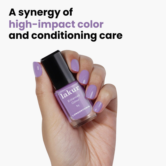 A hand showcasing a "Road Trip" bottle by LONDONTOWN with matching lavender nails, and the phrase "A synergy of high-impact color and conditioning care.