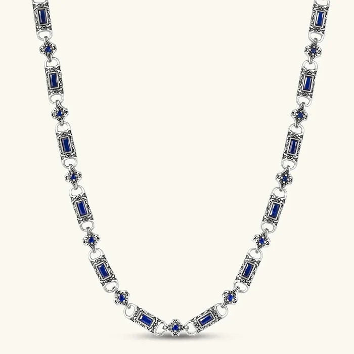 Link necklace in antique silver-tone metal with ornate scrollwork and alternating deep blue baguette-cut and round stones