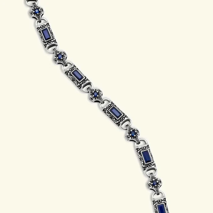 Blue cubic zirconia link necklace in ornate antique silver scrollwork, featuring Baguette-cut and round stones throughout.