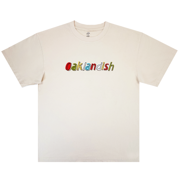 The Scrawl Tee by Oaklandish is a classic-fit men’s t-shirt in off-white, featuring colorful, outlined "Oaklandish" lettering on the chest. Made from heavy-weight cotton, it has short sleeves and a crew neckline for comfort and style.