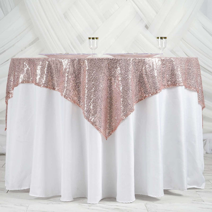 Rose gold sequin tablecloth draped over a white table