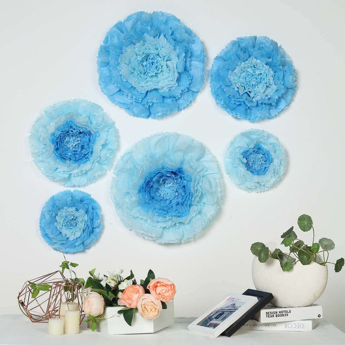 Blue paper flower wall decor arrangement with decorative plants and photo frames.