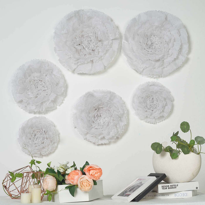 Decorative paper flowers on a wall with plants and books in a styled setting.