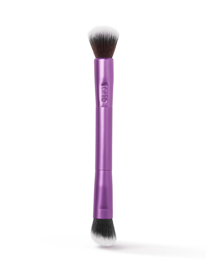A dual-ended makeup brush with purple handle, featuring soft bristles on both ends for versatile application. Tarte is embossed on the handle, set against a white background.
