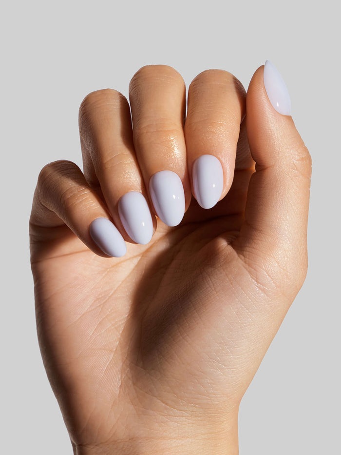 Hand with sky blue press-on nail on a neutral background