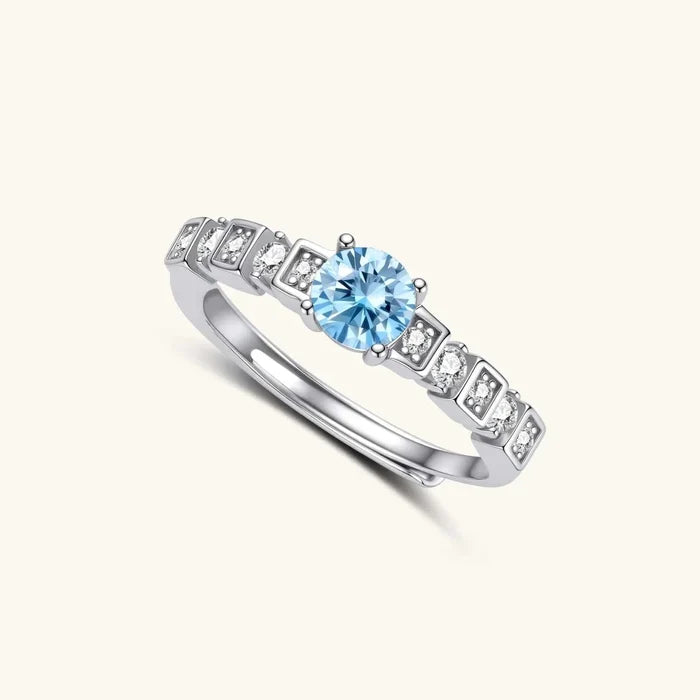 Skyline Light Blue Moissanite Ring in polished silver, with a round sky-blue center stone and geometric clear-stone accents