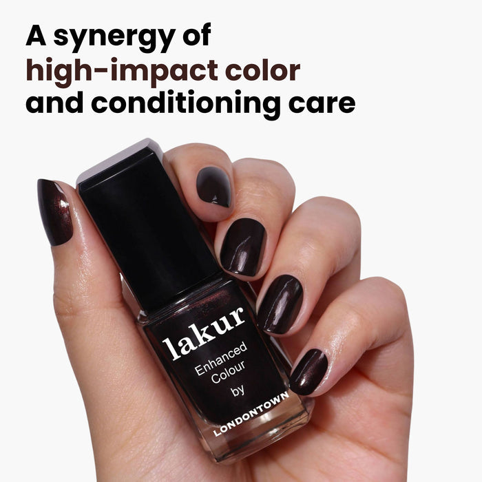 A hand holds a LONDONTOWN Spilled Wine bottle, dark as pinot noir. The label on the clean white background reads "A synergy of high-impact color and conditioning care.
