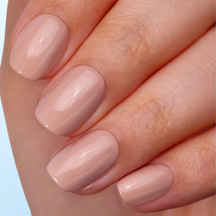 Close-up of neatly manicured fingernails painted in glossy nude beige, showcasing shiny nails after using LONDONTOWN's Strength & Shine Duo nail strengthener.