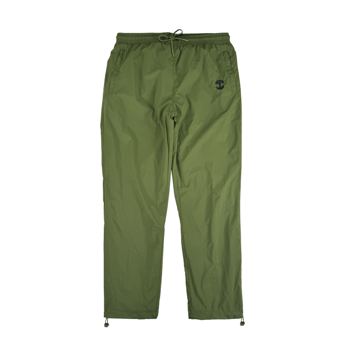The Oaklandish Susurrus Track Bottom is an olive green jogger-style nylon pant with an adjustable waistband, drawstring closure, side pockets, ankle drawstrings, and a black army-inspired logo on the upper left thigh. Laid flat on a white background.