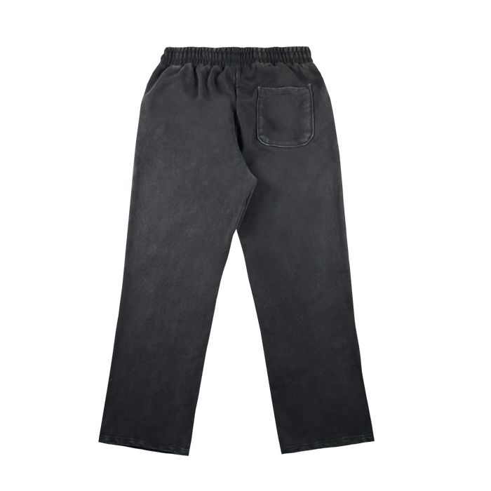 The Oakland Roots SC Tatsu Pants are black, straight-cut sweatpants made from soft organic cotton. Shown from the back on a white background, they feature an elastic waistband and a single right-side patch pocket.