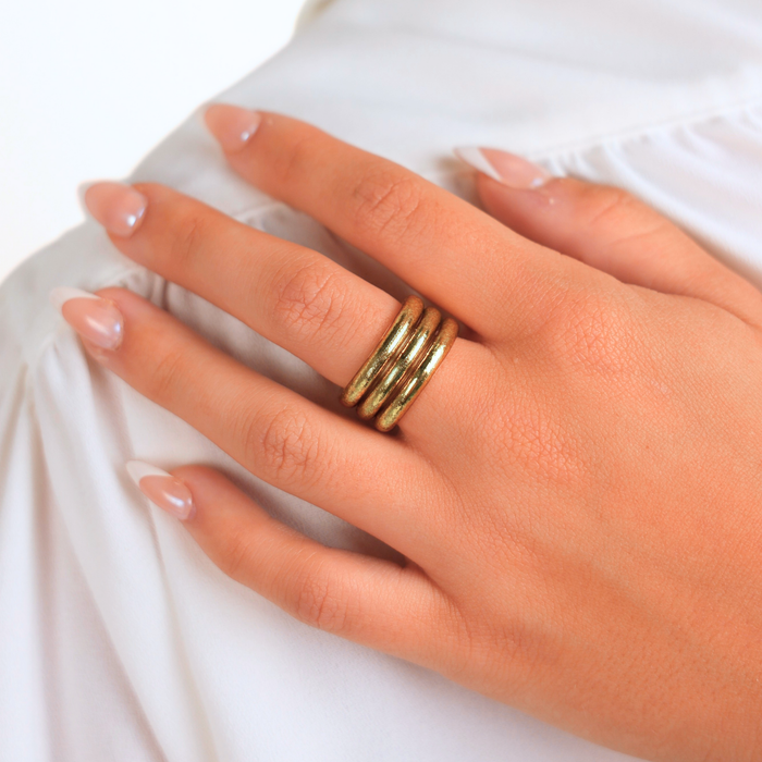 Hand wearing a gold ring on a white background