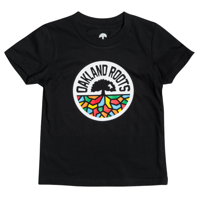 The Toddler Oakland Roots SC Classic Tee from Oakland Roots SC is a black T-shirt that prominently features a circular logo in the center. This logo showcases a black tree silhouette above bold, block letters spelling “OAKLAND ROOTS,” with colorful, abstract shapes resembling stained glass in red, yellow, green, and blue beneath the text—a perfect fit for any young fan of this vibrant sports club.