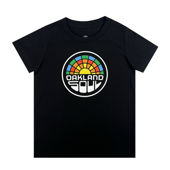 A black Toddler Oakland Soul Logo Tee from Oakland Soul featuring a vibrant, circular logo in the center. The logo has a rainbow-like design with segments in green, blue, red, orange, and purple, resembling a sunset. Below it is bold text reading "OAKLAND" and curved letters spelling "SOUL," representing the Oakland Soul women's soccer team from the USL W-League.