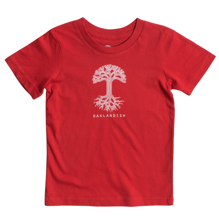 The Toddler Oaklandish Classic Logo Tee by Oaklandish features a red, short-sleeve T-shirt made from 100% cotton. It has a white graphic of a stylized tree with sprawling roots and branches, with "OAKLANDISH" printed in bold white capital letters below the tree. The shirt is displayed laid flat against a white background.