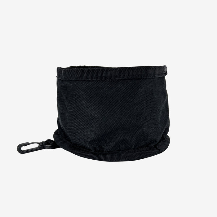 The Travel Pet Bowl by Oaklandish is a small, black, cylindrical pouch featuring a drawstring closure at the top and a side clip. Crafted from durable 600D polyester, this empty pouch stands upright, highlighting its simple yet functional design as an ideal portable pet accessory.