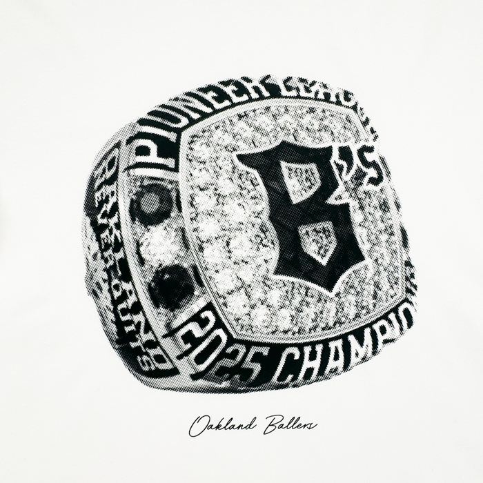 Black and white image of the Triumph Tee by Oakland Ballers. The design features a jeweled championship ring with a "B" and "Pioneer League Champions," celebrating the team as 2025 DEV GRANTS champions.