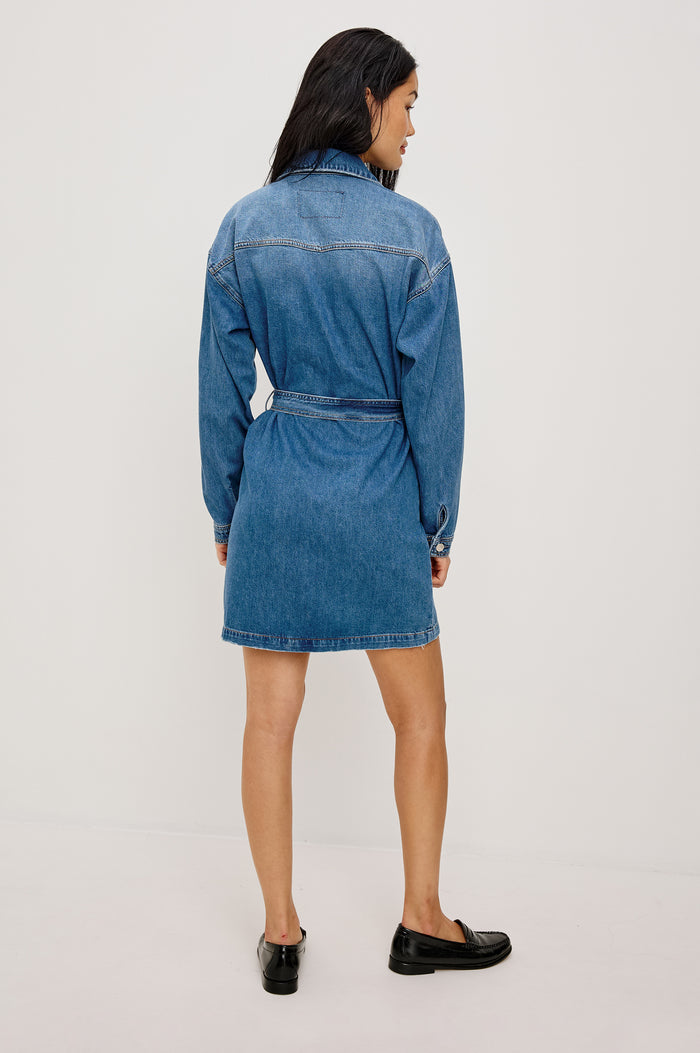 Tustin Mini Shirt Dress in Rigid Denim With Western Yoke, Front Buttons, Self Belt, Dropped Shoulders, and Long Sleeves in Skyride Colorway - Full Body Back View Featured on Model