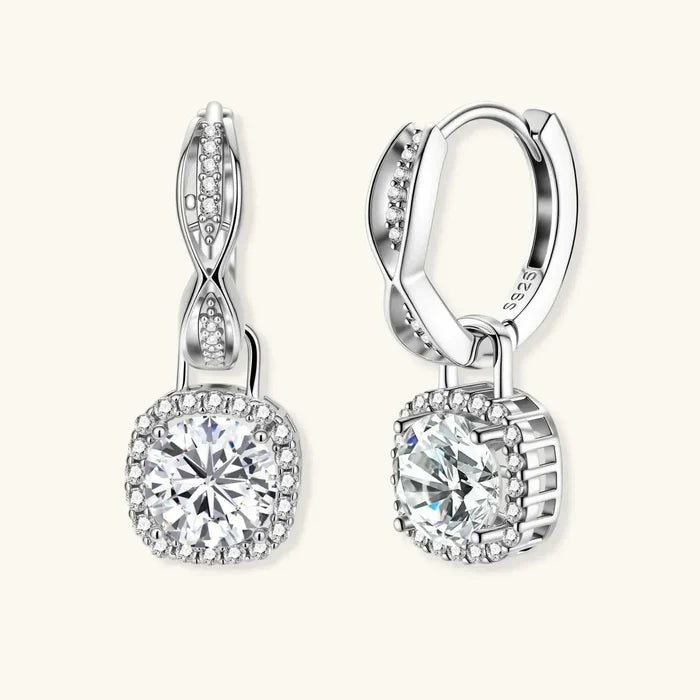Twisted Infinity Halo Moissanite Earrings in silver-tone metal, with sparkling twisted infinity huggie tops and round stones in cushion pavé halos.