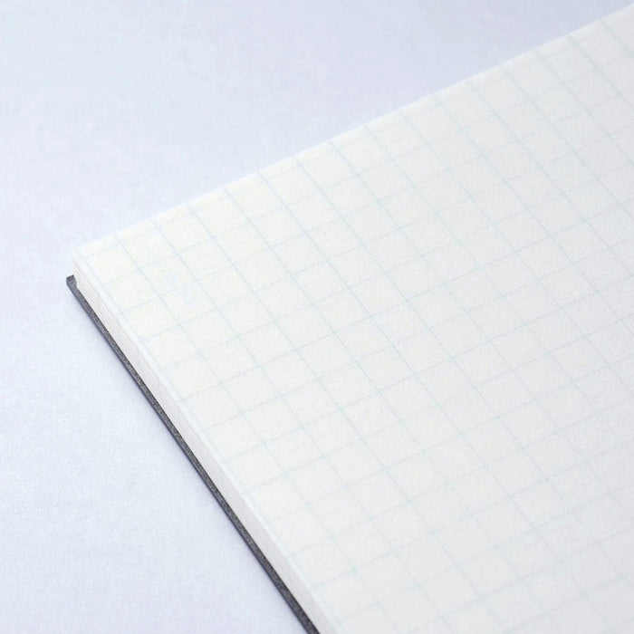 Close-up of a notebook with Gridded pages on a light gray background