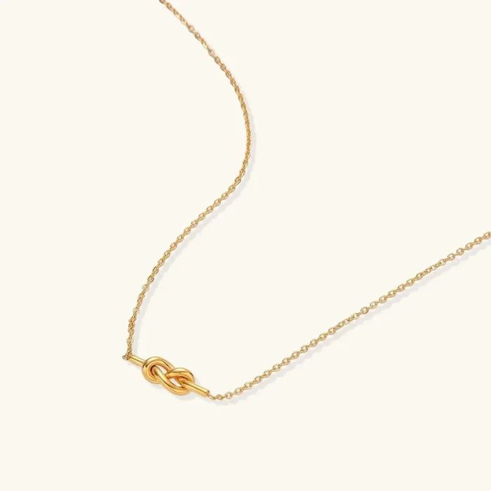 Unity Knot Necklace with a polished gold-tone finish, fine cable chain and small horizontal looped knot pendant