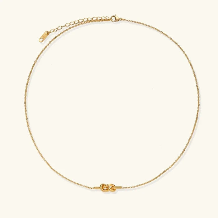 Unity Knot Necklace in polished gold tone, with a fine cable chain and a small horizontal looped knot pendant.