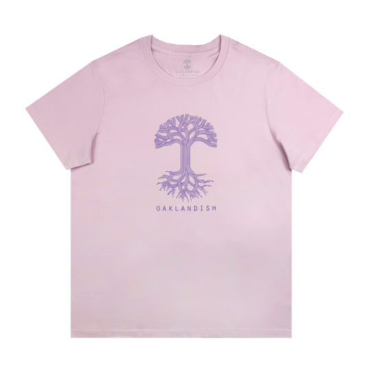 The Women's Oaklandish Classic Logo Tee, a 100% cotton light orchid pink t-shirt, displays a stylized purple tree with intricate roots and branches centered above "OAKLANDISH" in purple.