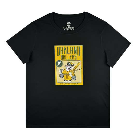 Women’s Scrappy Rookie Card Tee by Other: Black T-shirt showcasing a yellow graphic of cartoon possum Scrappy the Rally Possum holding a baseball bat, wearing sunglasses and a cap—an homage to the Oakland Ballers mascot. Bold “OAKLAND BALLERS” lettering appears above with “SCRAPPY THE POSSUM” below. Brand label at the neck reads “Other”.