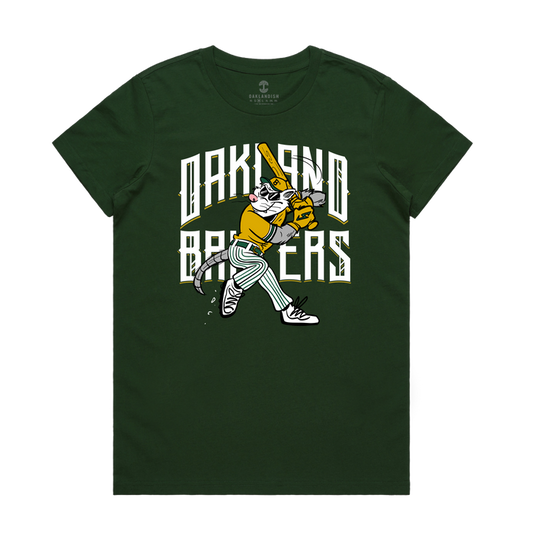 The Women’s Slugging Scrappy Tee by Other is a green t-shirt adorned with a cartoon cat dressed in a yellow baseball uniform swinging a bat, set against bold white “Oakland Batsers” lettering in a stylized font—an ideal pick for Oakland baseball fans or anyone who enjoys fun tributes to local icons like Scrappy the Rally Possum.
