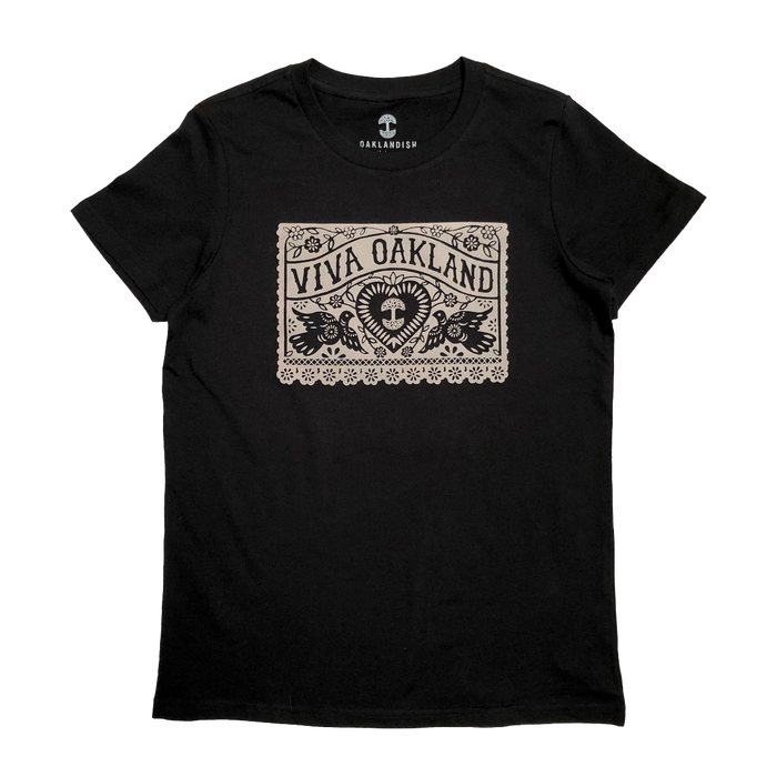 The Women's Viva Oakland Tee by Oaklandish is a black T-shirt made from 100% cotton, featuring a bold beige rectangular graphic with the words "Viva Oakland." Below the graphic, a heart rests amid artistic leaf and flower designs. This classic fit tee comes with the "Oaklandish" logo printed on the inside neckline.