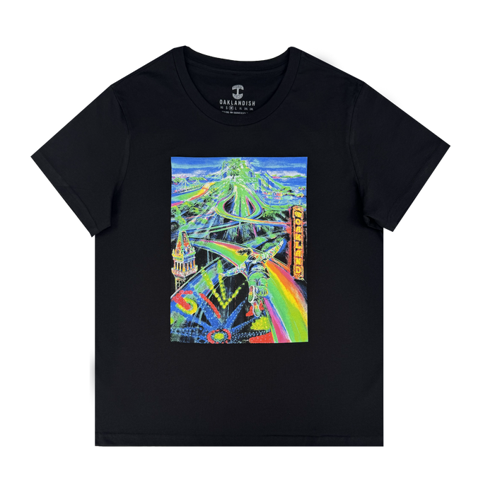 The Women’s Yay Area Tee by Other is a black cotton shirt featuring vibrant, neon-painted Oakland cityscape art with highways, bridges, and the iconic “Oakland” sign in bold yellow lettering. The dynamic urban landmarks stand out in a surreal artistic style against the dark fabric.