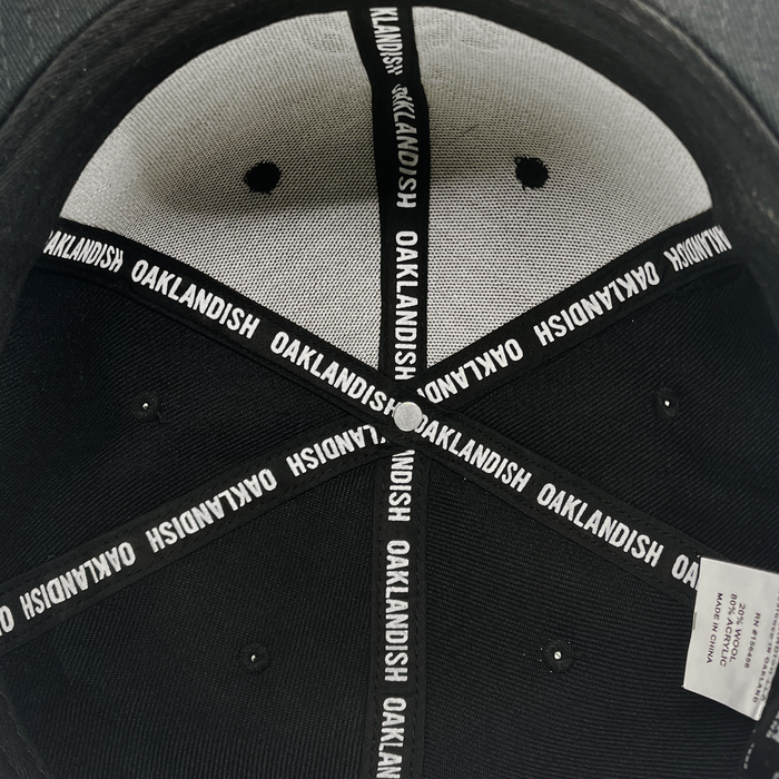 Detailed close up of Oaklandish  taping inside the crown of black cap.