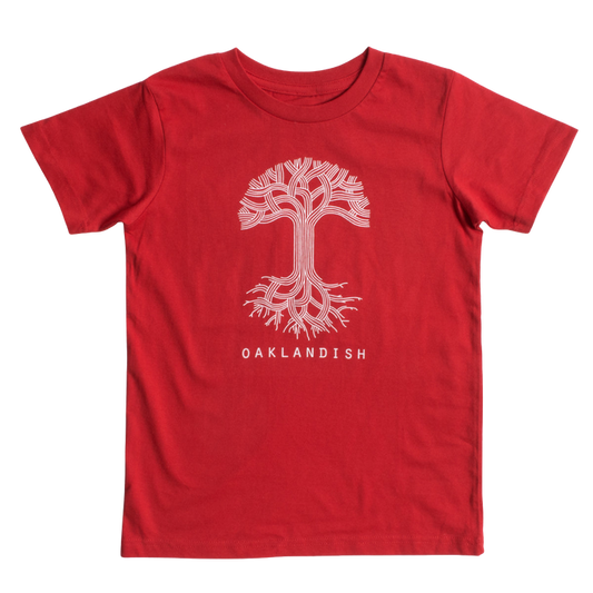 The Youth Oaklandish Classic Logo Tee by Oaklandish is a red T-shirt showcasing a white graphic design of a tree with winding branches and roots in the center. Below the tree graphic, the word "OAKLANDISH" is printed in white capital letters. Made from 100% cotton, this kids' shirt is displayed flat against a plain white background.