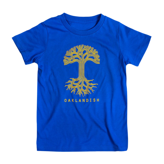 The Youth Oaklandish Classic Logo Tee by Oaklandish is a royal blue youth T-shirt made from 100% cotton. It features a stylized yellow tree design with intricate, symmetrical branches and roots extending from the center. Below the tree, the word "OAKLANDISH" is printed in bold capital letters.